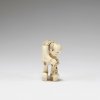 Netsuke. Man, lacing his shoe